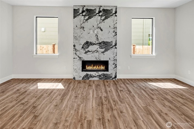 21402 39th Dr SE Unit A, Bothell, WA 98021 - unfurnished living room featuring a premium fireplace, wood finished floors, and baseboards