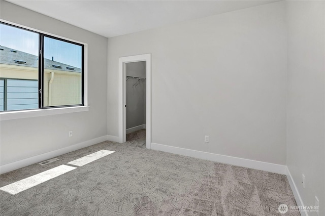 21402 39th Dr SE Unit A, Bothell, WA 98021 - unfurnished bedroom featuring carpet floors, baseboards, a walk in closet, and a closet