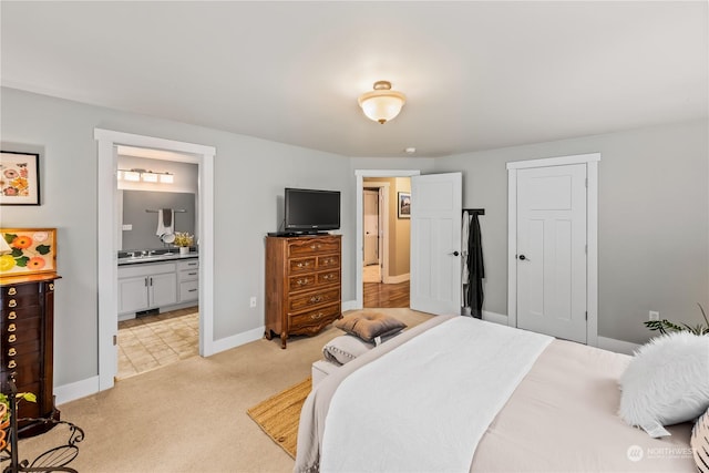 carpeted bedroom with ensuite bathroom and a closet