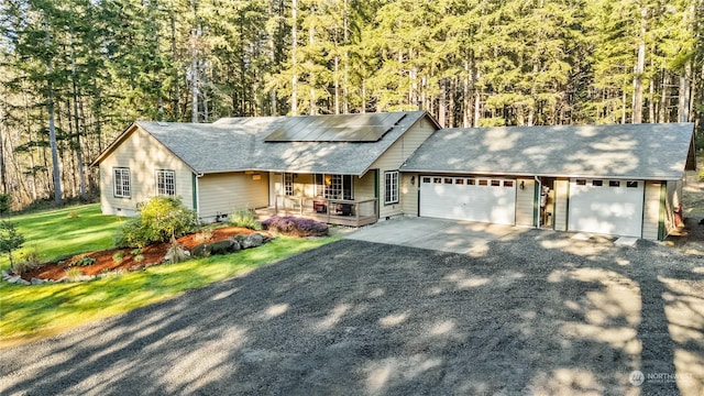 ranch-style house with a garage, a front yard, solar panels, and a porch