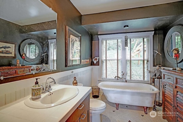 bathroom with vanity, a bath, tile patterned floors, and toilet