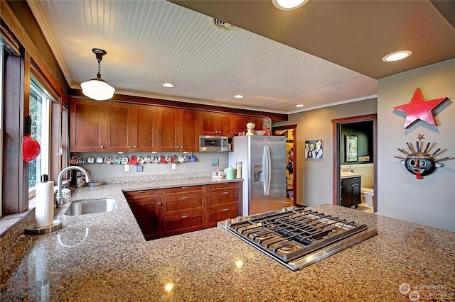 kitchen featuring sink, hanging light fixtures, ornamental molding, stainless steel appliances, and light stone countertops