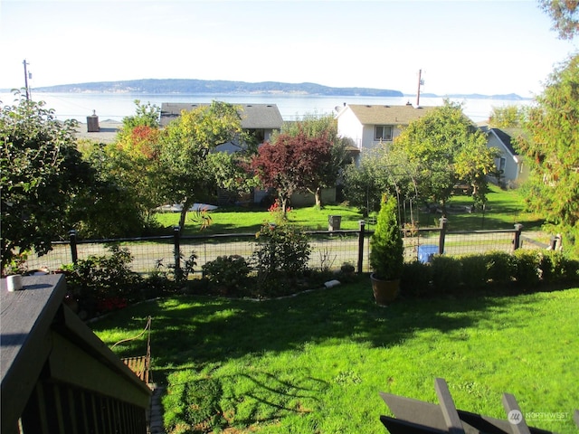 view of community featuring a water and mountain view and a lawn