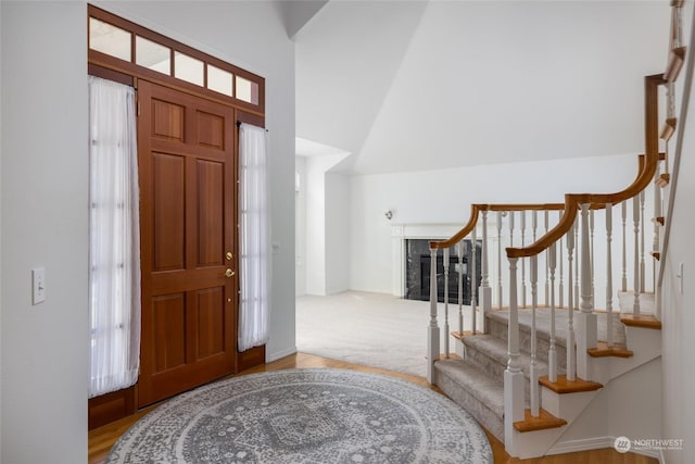 carpeted entryway featuring a high end fireplace and a wealth of natural light