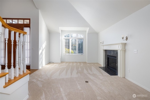 unfurnished living room featuring a premium fireplace, light carpet, and high vaulted ceiling