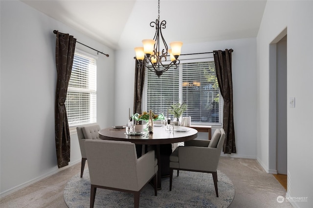 dining room featuring an inviting chandelier, light colored carpet, and lofted ceiling