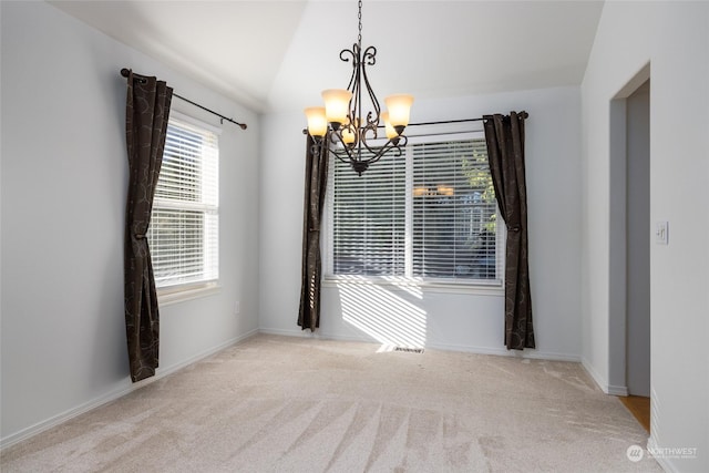 carpeted empty room with a notable chandelier