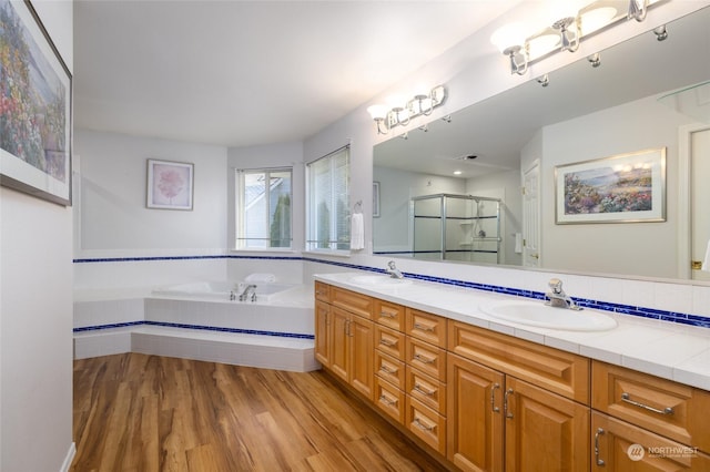 bathroom featuring hardwood / wood-style flooring, vanity, and separate shower and tub