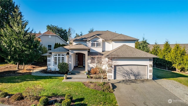 view of property featuring a garage and a front lawn