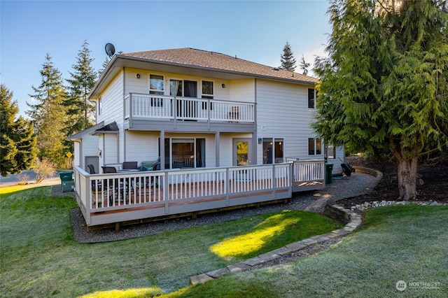 back of house with a wooden deck, a yard, and a balcony