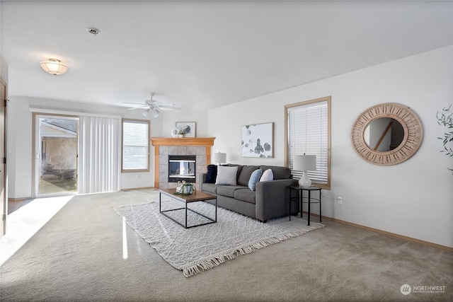 living room featuring light colored carpet, a tile fireplace, and ceiling fan