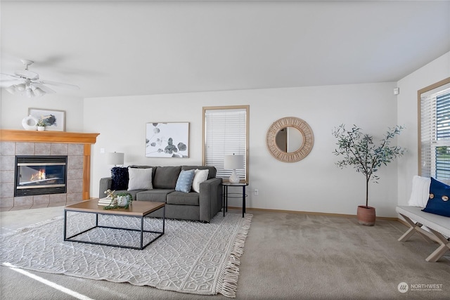 living area with carpet floors, ceiling fan, a fireplace, and baseboards