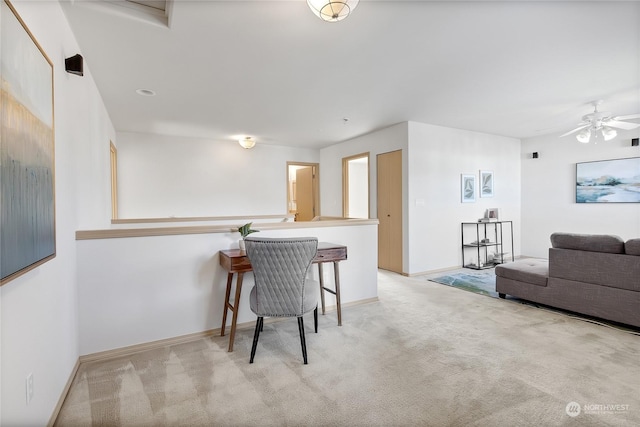 interior space with ceiling fan, baseboards, and light colored carpet