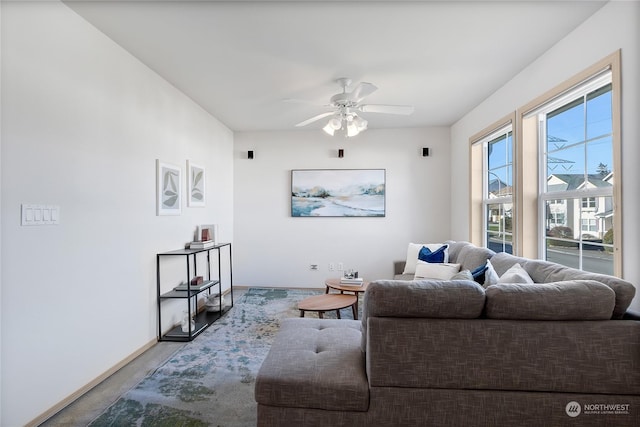 living area with ceiling fan and baseboards