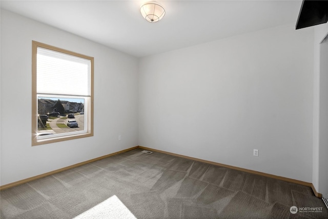 unfurnished room featuring carpet floors and baseboards