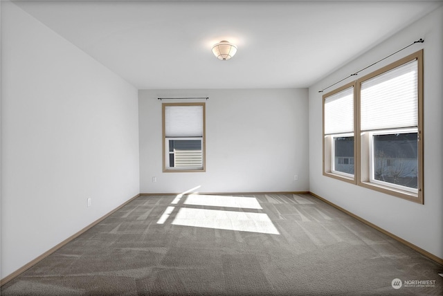 unfurnished room with carpet flooring and baseboards