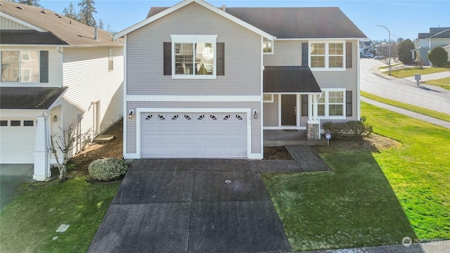 traditional-style home featuring driveway, an attached garage, and a front yard