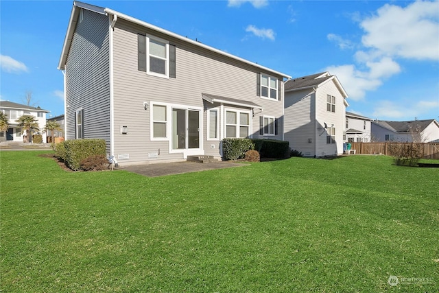 rear view of house featuring a patio area, a lawn, and fence