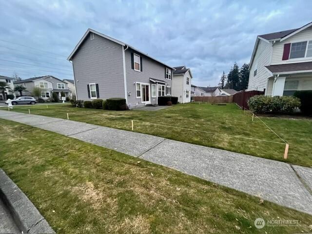 view of property exterior featuring a yard, a residential view, and fence