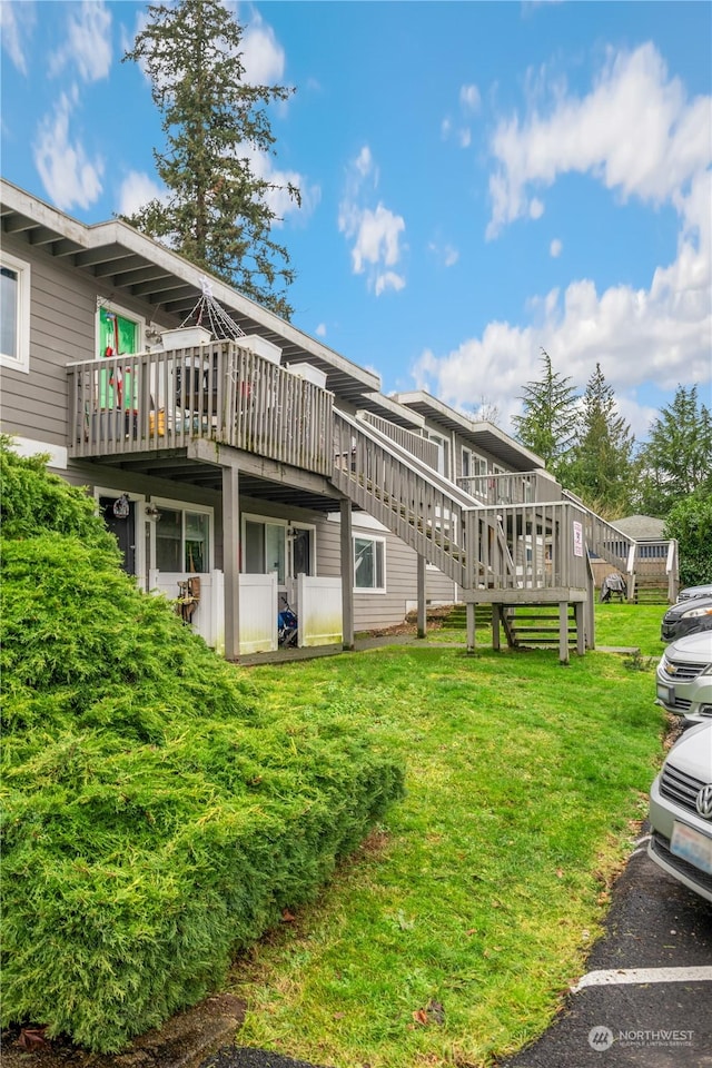 back of house featuring a wooden deck and a yard