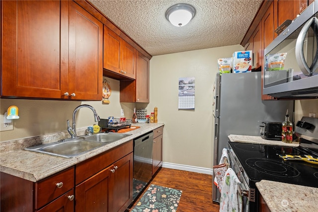 kitchen featuring stainless steel appliances, dark hardwood / wood-style floors, sink, and a textured ceiling