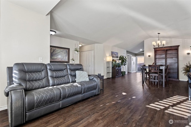 living room featuring vaulted ceiling, dark hardwood / wood-style floors, and a notable chandelier