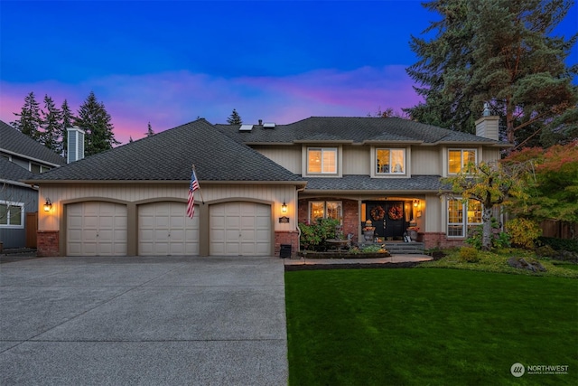 view of front facade with a garage and a yard