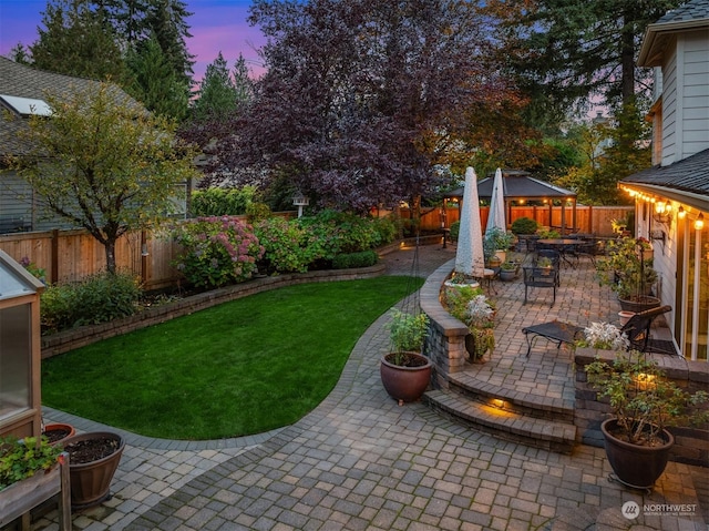 yard at dusk featuring a patio