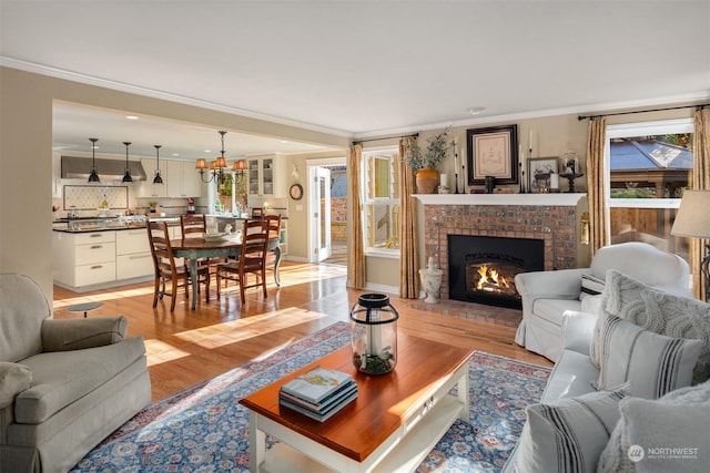 living room with ornamental molding, a fireplace, and light wood-type flooring