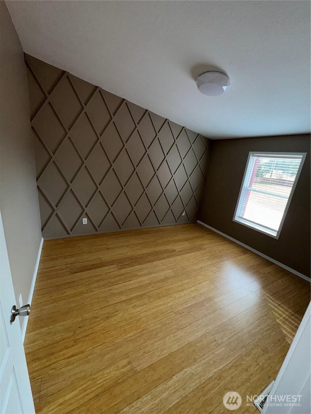 empty room featuring light wood-style flooring and baseboards