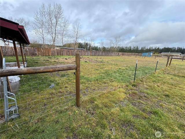 view of yard featuring fence and a rural view