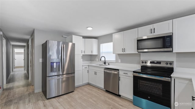 kitchen with white cabinetry, sink, and stainless steel appliances