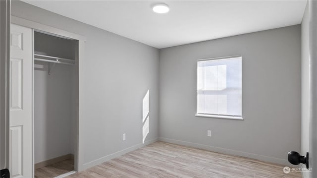 unfurnished bedroom with a closet and light wood-type flooring