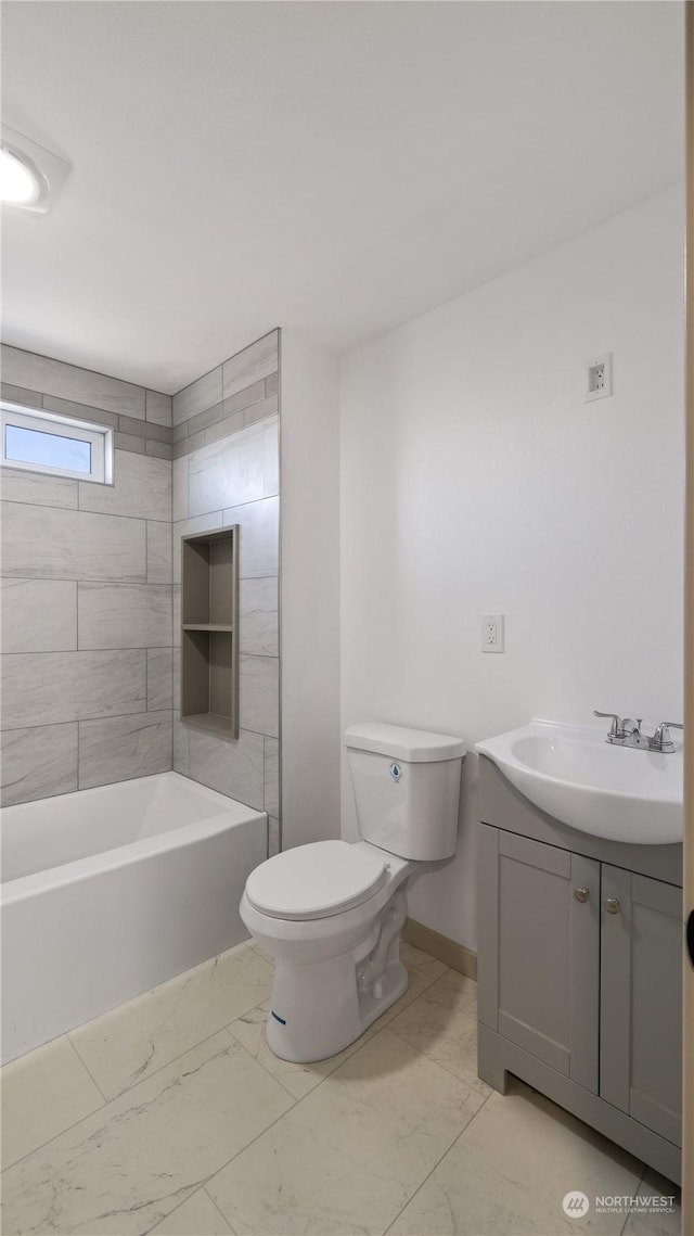 full bathroom featuring vanity, tiled shower / bath combo, and toilet