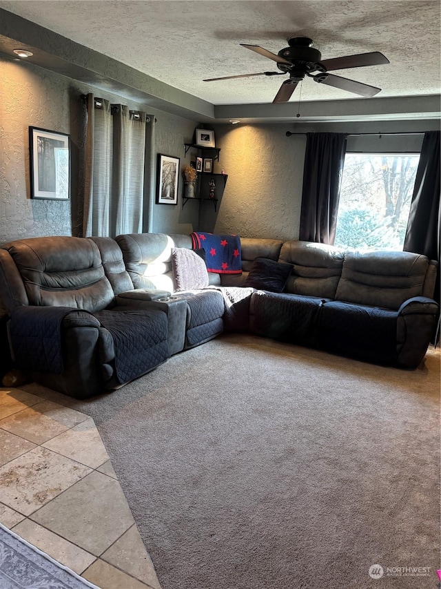 tiled living room with a textured ceiling, a textured wall, and a ceiling fan