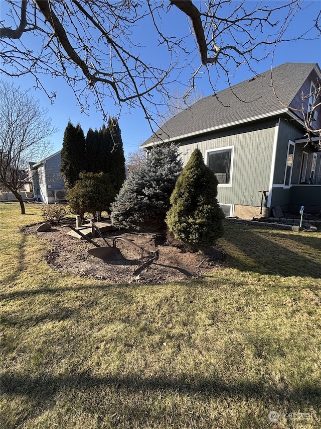 exterior space with a yard and a shingled roof