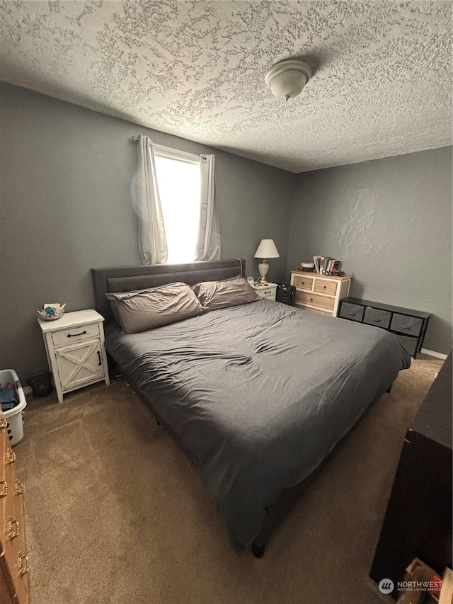 bedroom featuring a textured ceiling and dark colored carpet