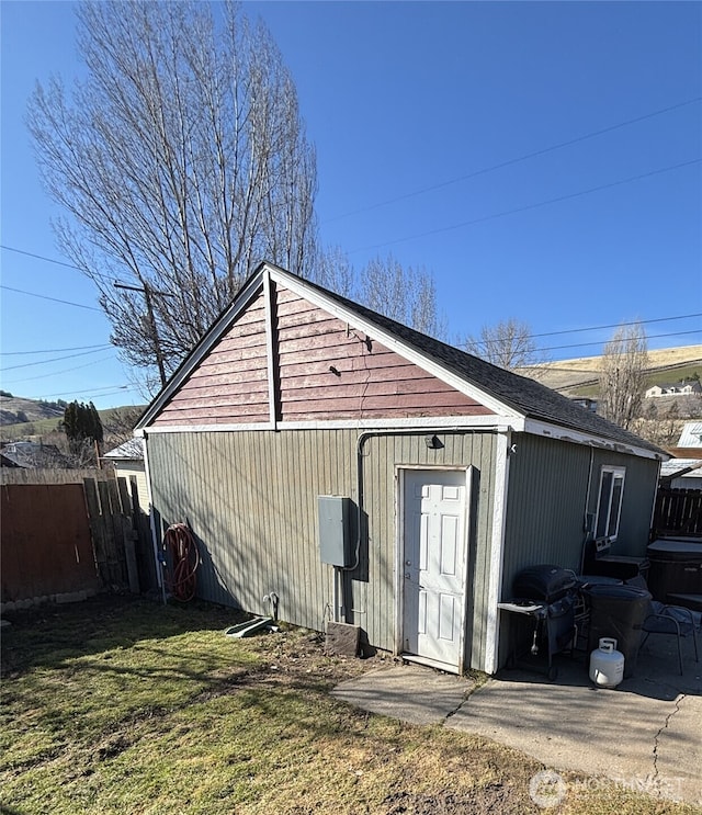 exterior space with a lawn, an outdoor structure, and fence