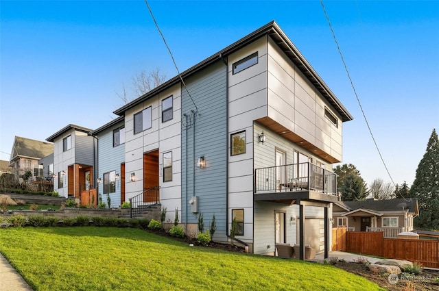 back of property featuring a garage and a lawn