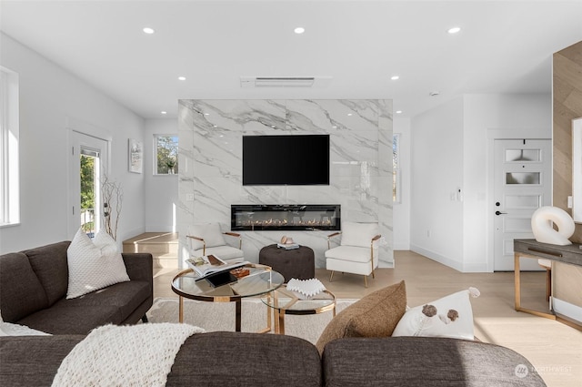 living room with a premium fireplace and light hardwood / wood-style flooring