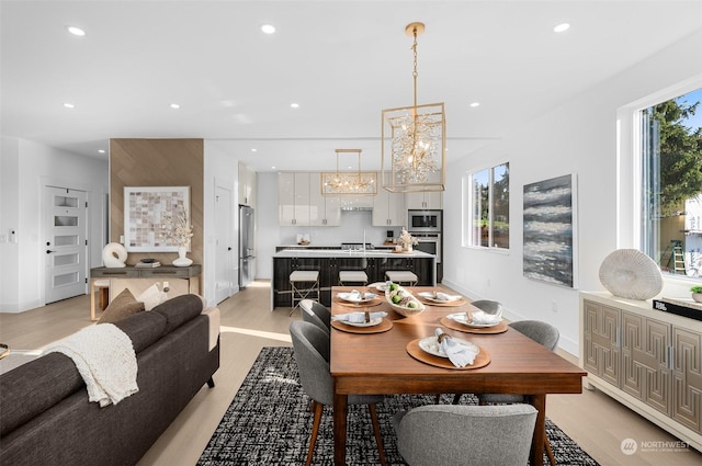 dining space featuring light hardwood / wood-style floors and a notable chandelier