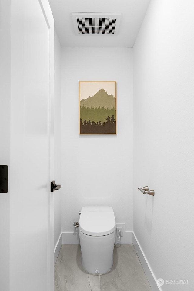 bathroom with toilet and concrete flooring