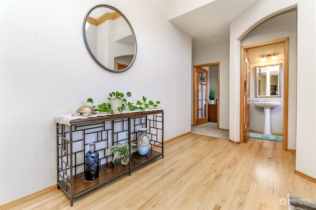 hallway with sink and light wood-type flooring