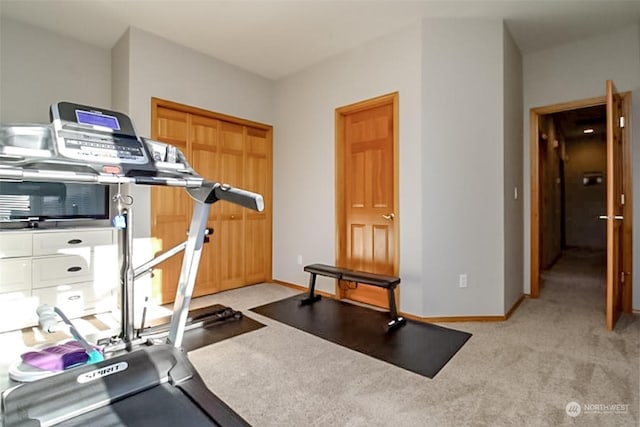 workout room featuring light carpet