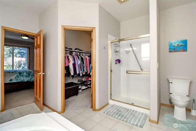 bathroom featuring a shower with shower door and toilet