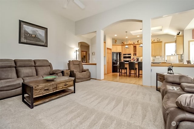 living room featuring ceiling fan, lofted ceiling, and light carpet