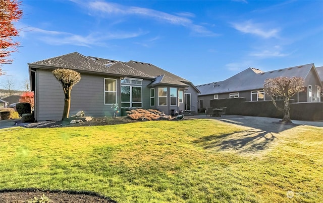 rear view of house with a yard and a patio area