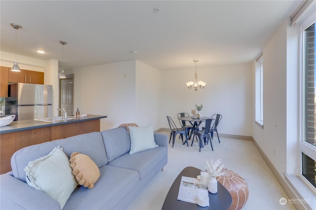 living room featuring sink, light colored carpet, and a chandelier