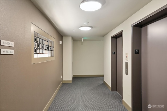 hallway featuring elevator and carpet floors