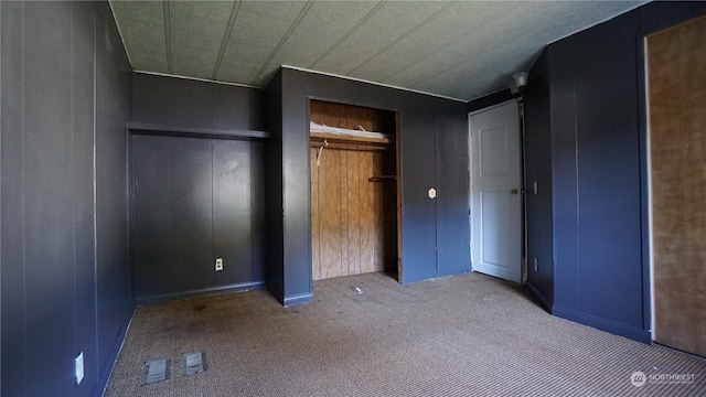 unfurnished bedroom with wood walls and carpet